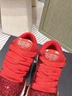 Top view of red glitter lace-up sneakers with Amiri tongue label and white sole