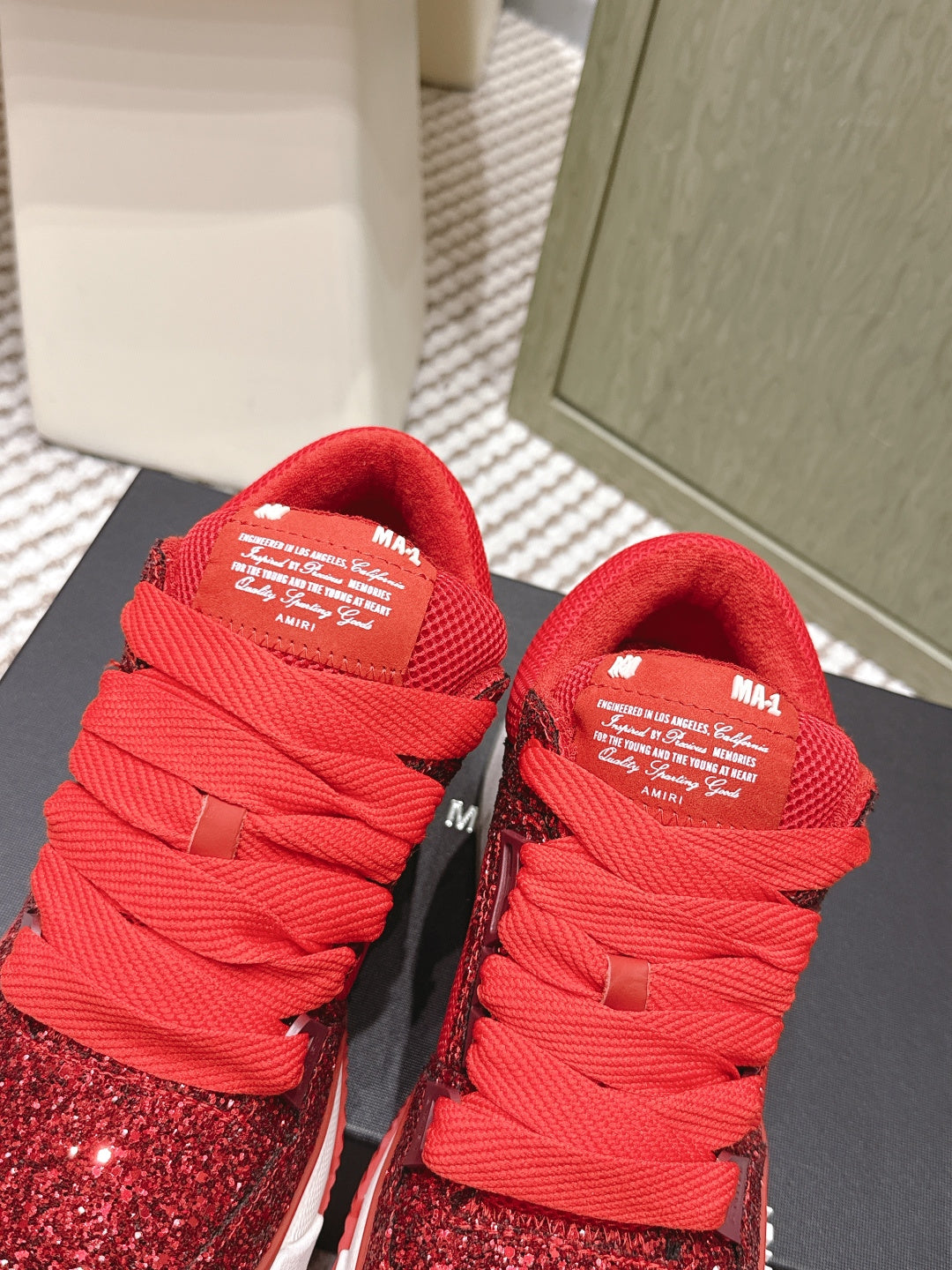 Top view of red glitter lace-up sneakers with Amiri tongue label and white sole