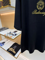 Dark short-sleeve T-shirt with Balenciaga gold script logo at chest