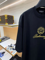 Dark short-sleeve T-shirt with Balenciaga gold crest and script logo