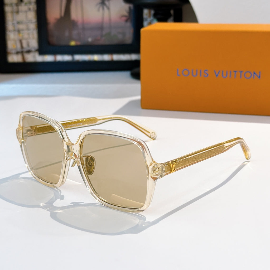 Clear-framed sunglasses with gold detailing and light tan lenses