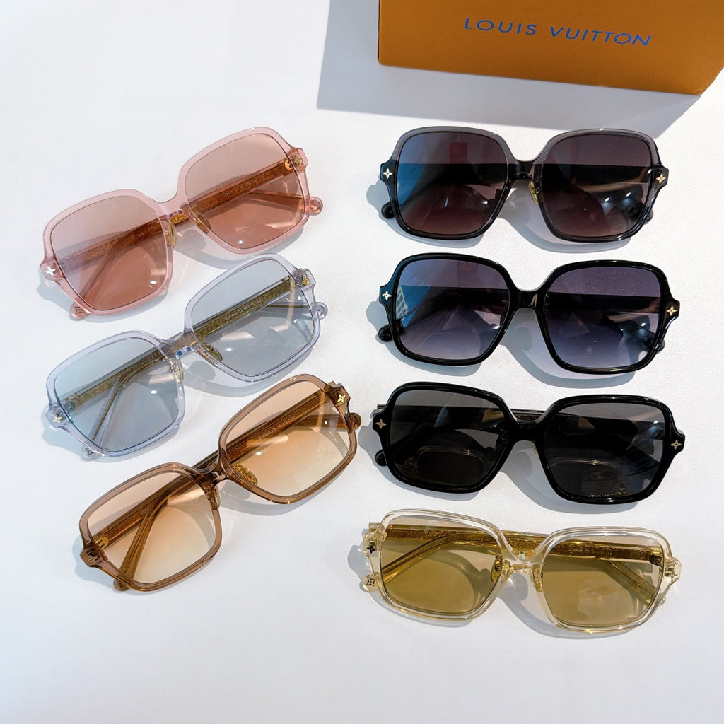 Assorted sunglasses laid out in mixed colors: black, blue, pink, tan, and gold