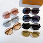 Assorted sunglasses laid out in mixed colors: black, blue, pink, tan, and gold