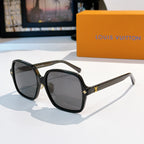 Black oversized sunglasses with dark lenses and gold star-like temple accents