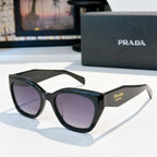 Prada sunglasses with black frames and purple tinted lenses, oversized round cat-eye