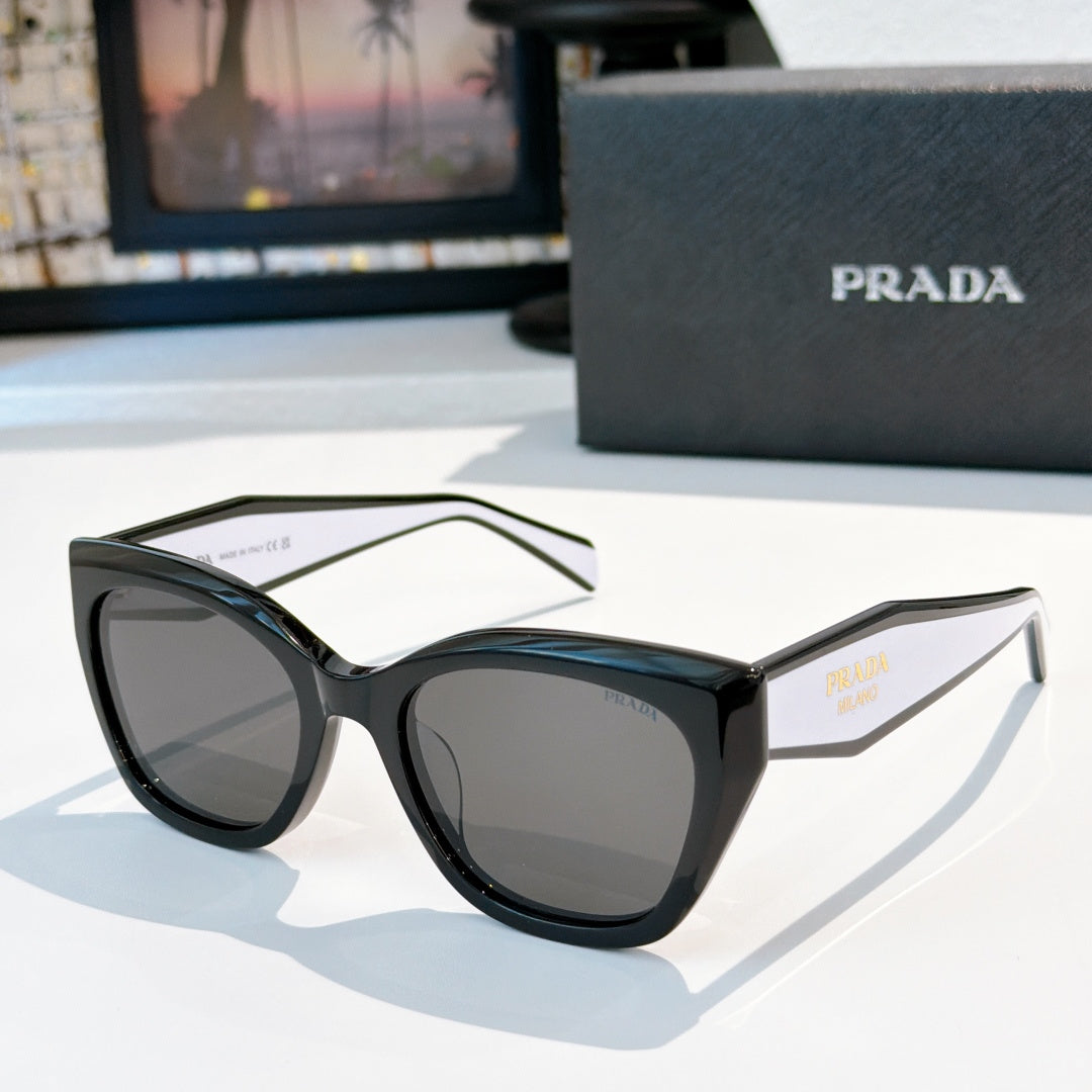 Prada sunglasses with black frames and dark gray tinted lenses, oversized rounded cat-eye