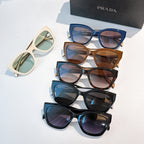 Prada sunglasses set with multiple frames and tinted lenses, blue, tan, and black pairs