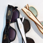 Prada sunglasses assortment with black and tan frames and tinted lenses, stacked pair view