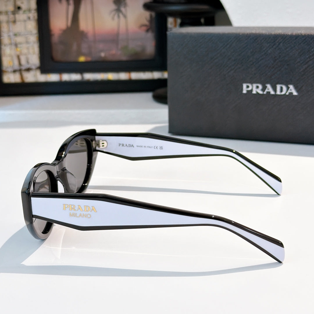Prada sunglasses with black frame and tinted lenses, temple branding visible.