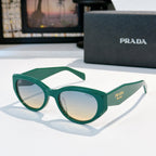 Prada cat-eye sunglasses with green frame and reflective tinted lenses.