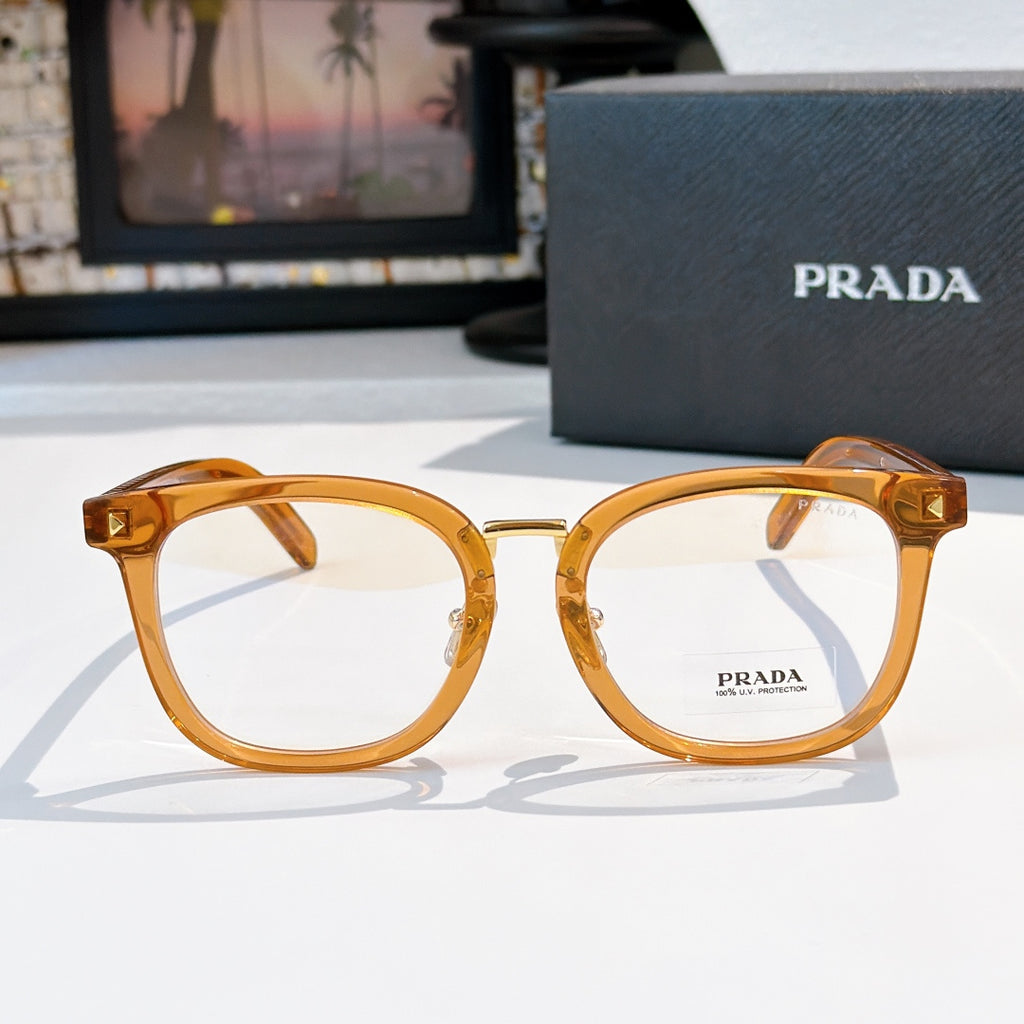 Prada eyeglasses with honey-tan full-rim oval frames and gold metal hinges.