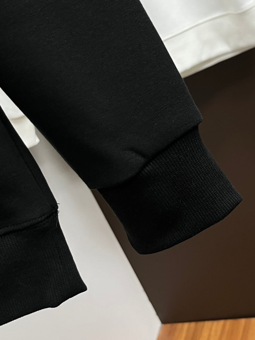 Black sweatshirt sleeve cuff and hem ribbing detail