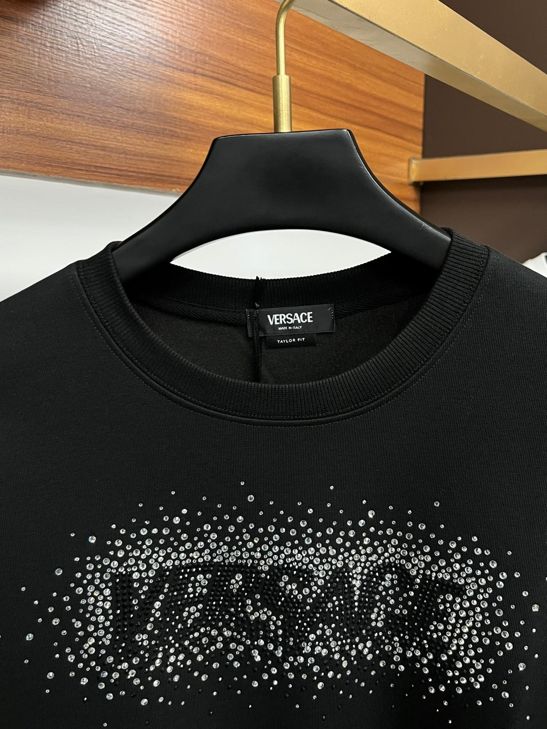 Black VERSACE sweatshirt neckline with studded logo graphic at the chest