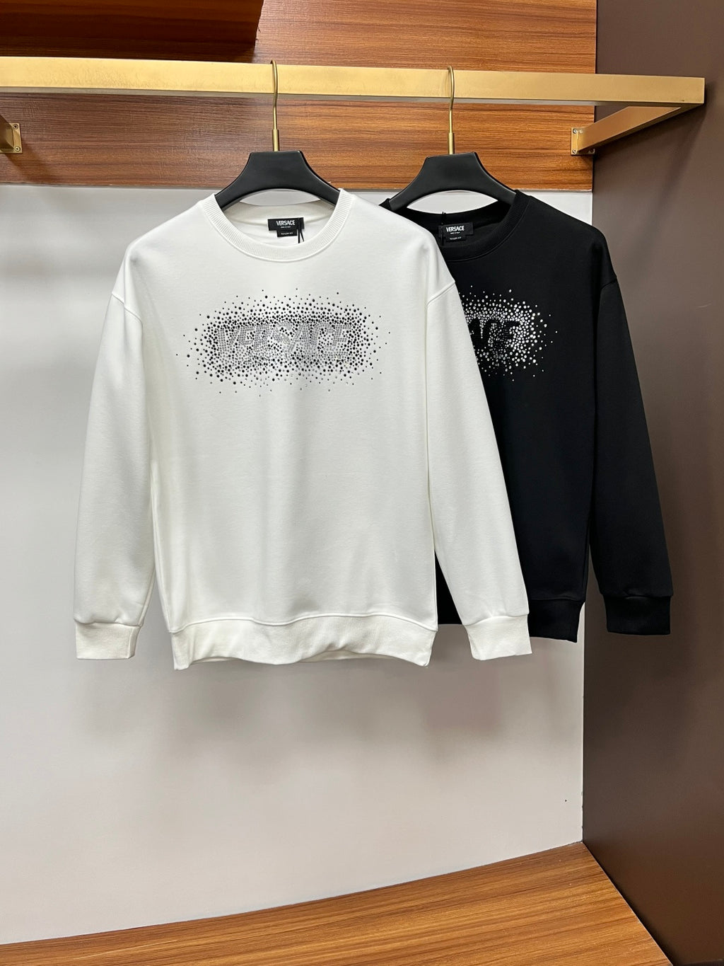 Black crewneck sweatshirt with rhinestone logo detail on chest