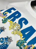 White sweatshirt sleeve close-up with blue VERSACE letters and ornate figures