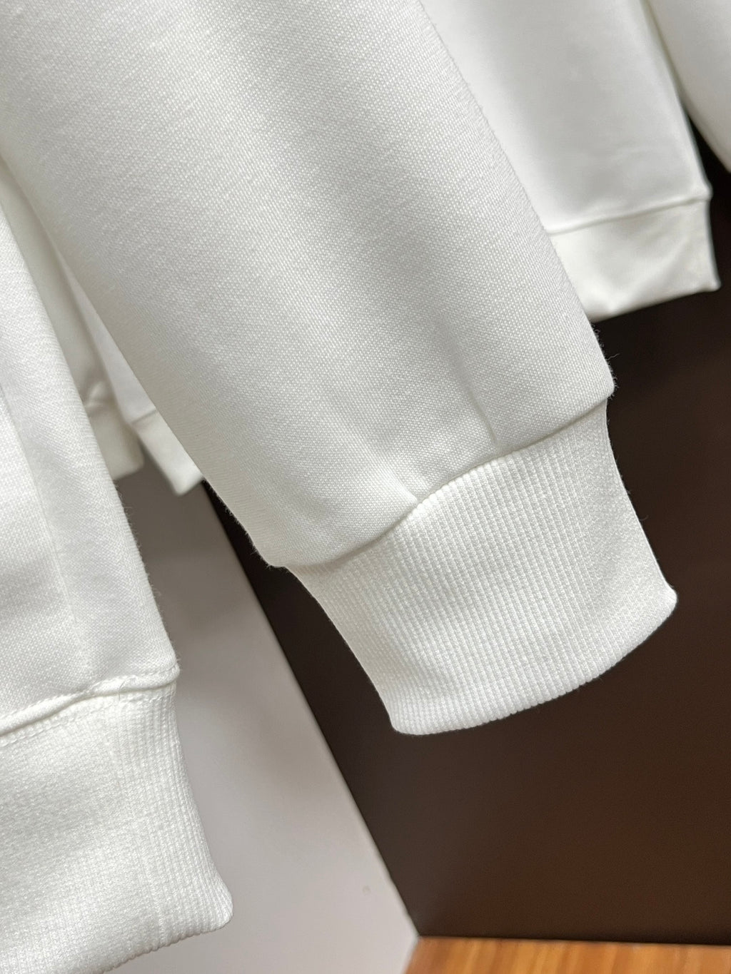 White sweatshirt sleeve and hem with ribbed cuffs and knit texture