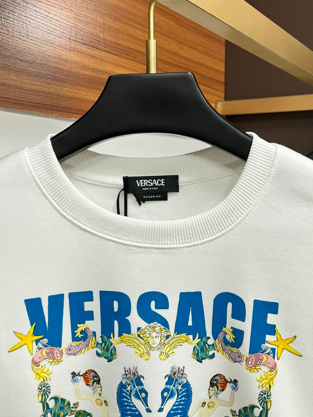 White crewneck sweatshirt with VERSACE logo label at neckline and ribbed collar