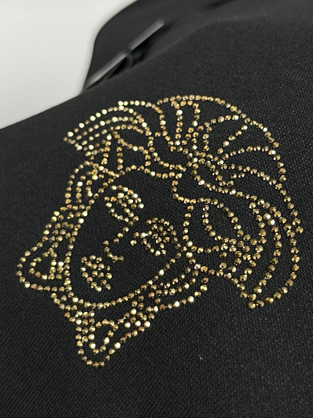 Gold-tone studded lion head motif on black sweatshirt chest