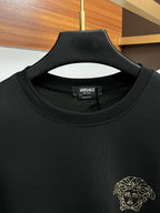 Black crewneck sweatshirt with VERSACE label and gold-tone studded lion head