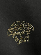 Gold-tone studded lion head embellishment on black sweatshirt fabric