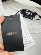 Versace sweatshirt with black Versace tag and care labels near collar