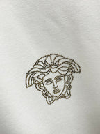 Rhinestone Medusa logo on white Versace sweatshirt fabric