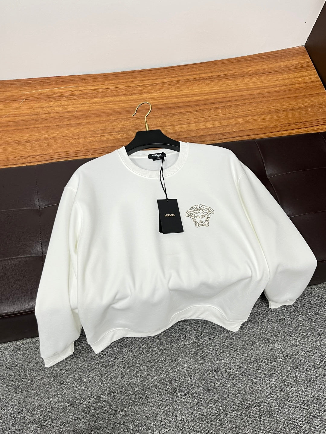 White Versace crewneck sweatshirt on hanger with Medusa logo and black tag