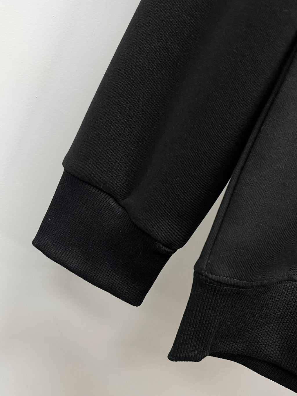 Black crewneck sweatshirt cuffs and ribbed hem detail