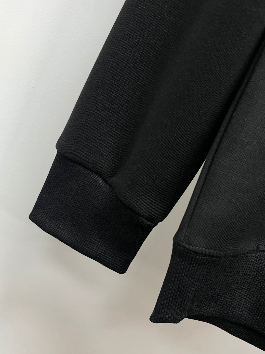Black crewneck sweatshirt cuffs and ribbed hem detail