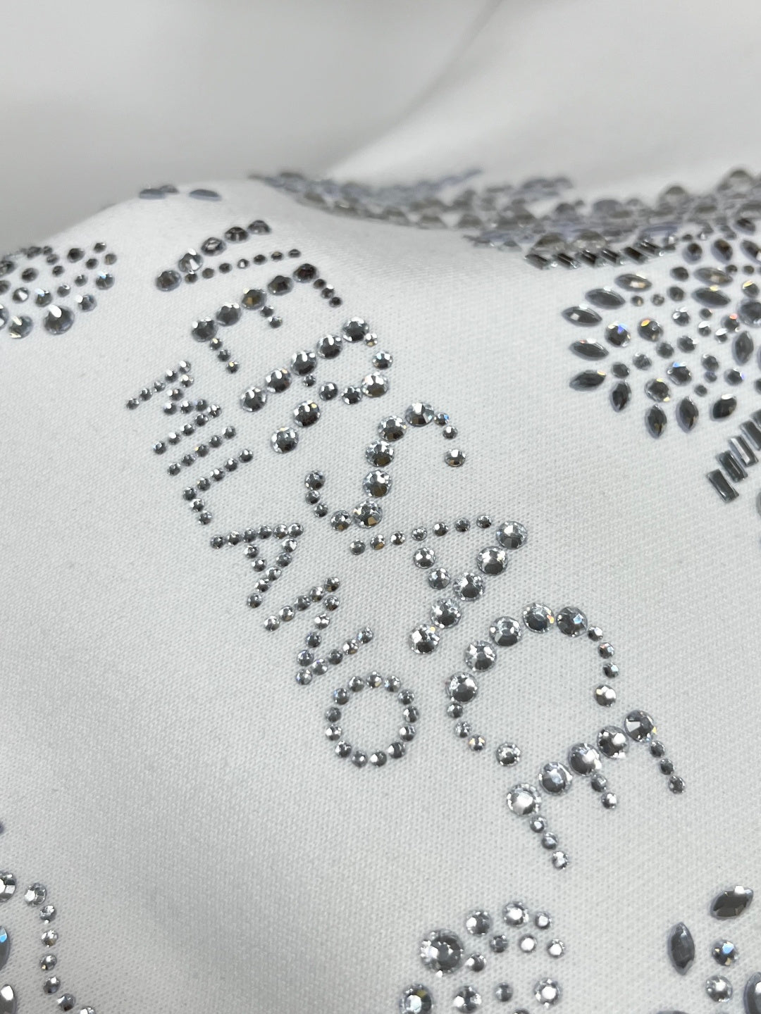 White sweatshirt with large rhinestone lettered design on front