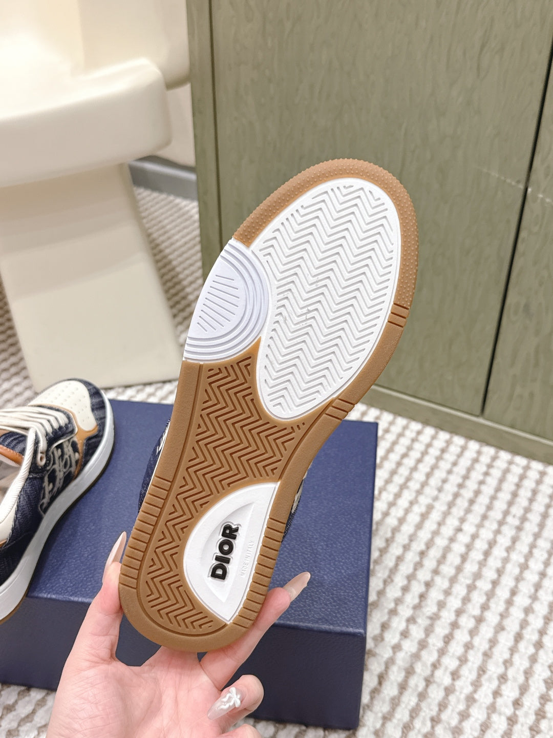 Outsole of low-top sneakers showing Dior text and zigzag tread on the gum rubber sole