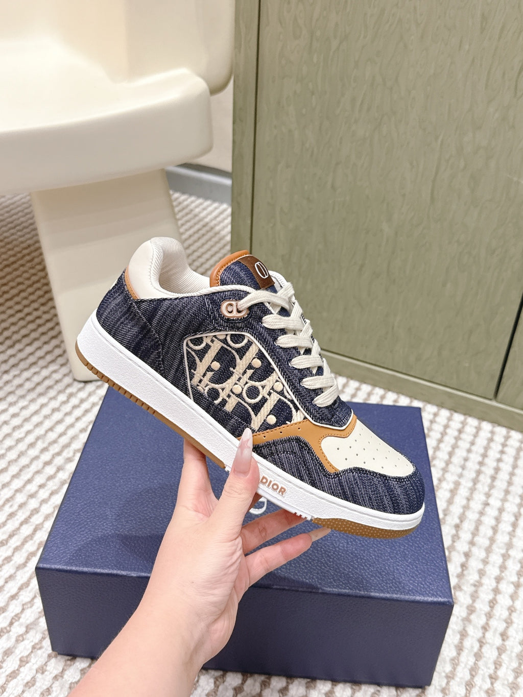 Navy and cream low-top sneakers with tan trim and Dior monogram pattern on side