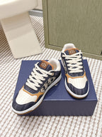 Pair of navy and white low-top sneakers with tan heel trim and white lace-up design