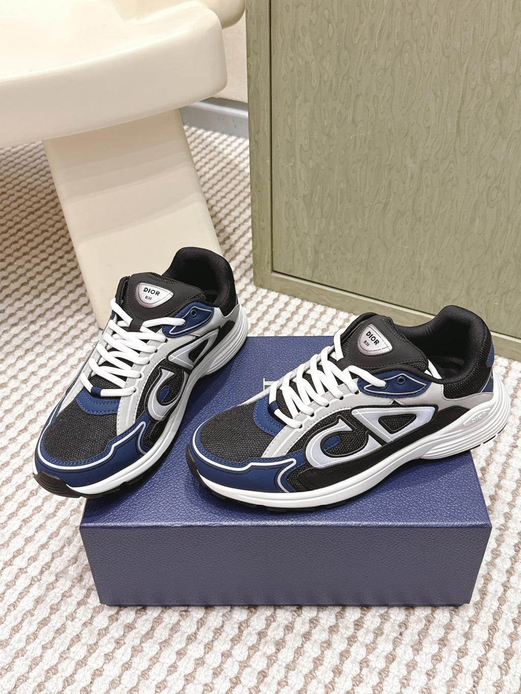 Dior unisex sneakers on a box, navy and black uppers with white lace trim