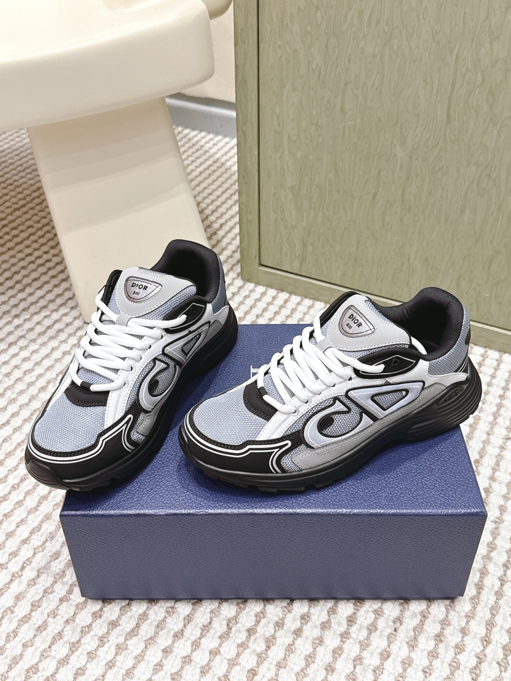Navy and white Dior low-top sneakers with white laces and black outsole.