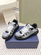 Navy and white Dior low-top sneakers with white laces and black outsole.