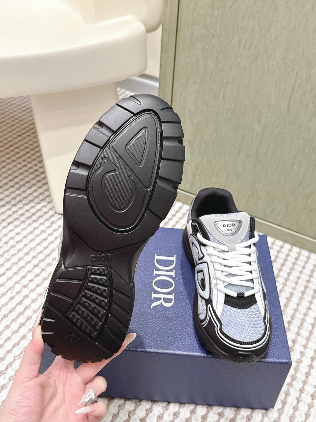Outsole view of Dior sneakers with tread pattern and DIOR branding.