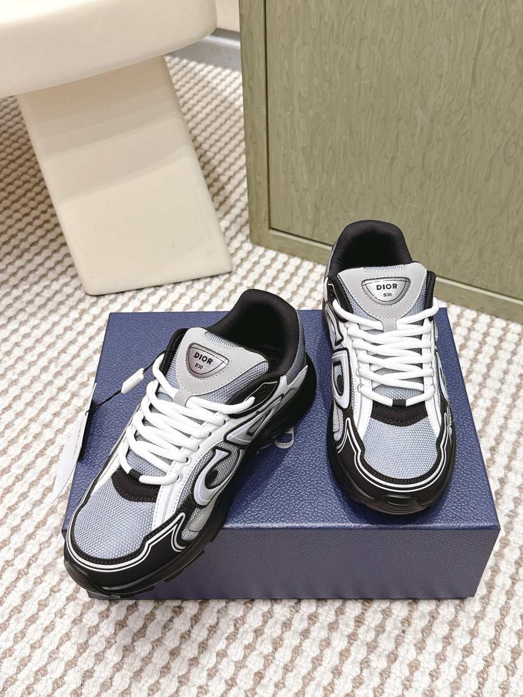 White and navy Dior sneakers with black toe cap and white lace-up.
