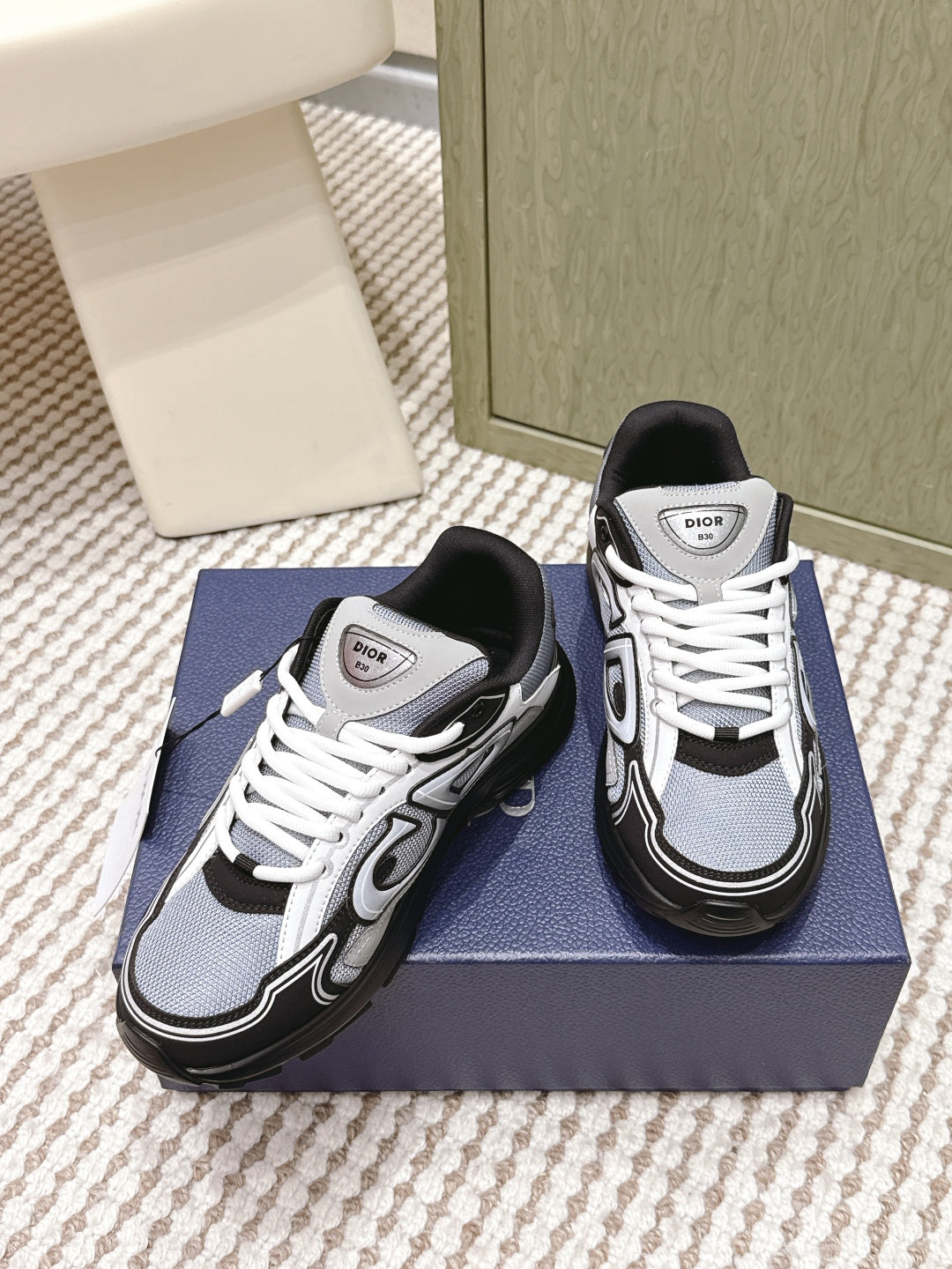 White and navy Dior sneakers with black toe cap and white lace-up.