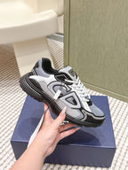 White and gray Dior sneakers with chunky black sole and white laces.