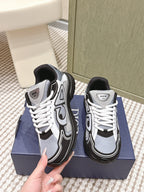 White and navy Dior sneakers with white laces and black side detailing.