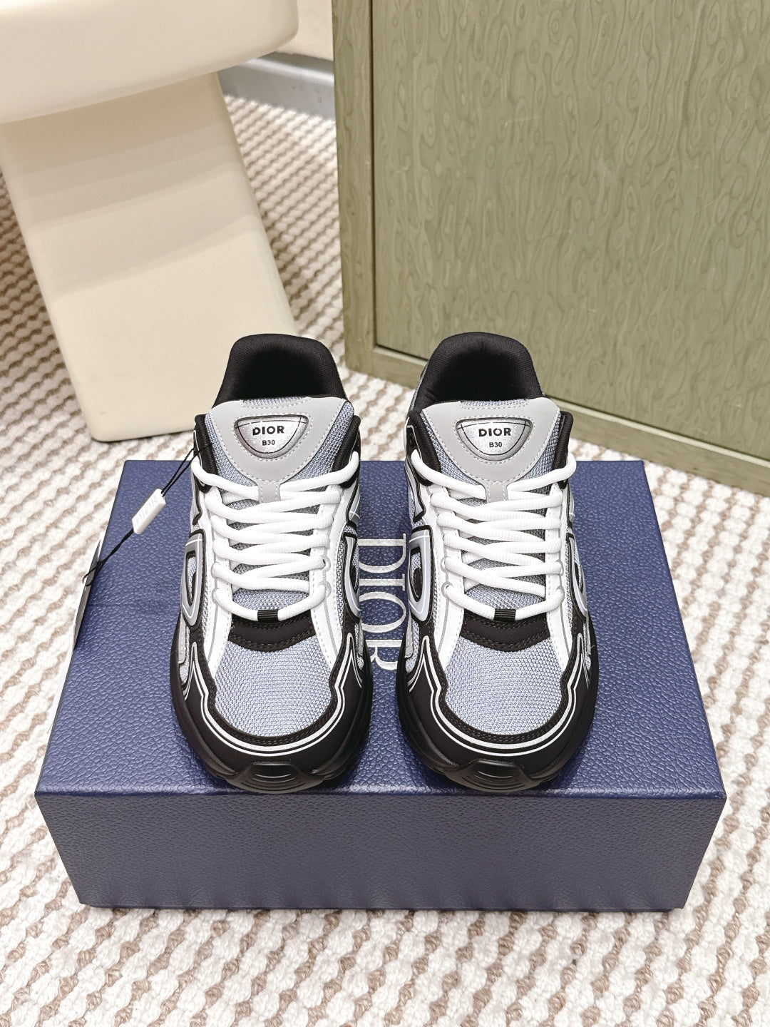 Navy and white Dior sneakers with white laces and black trim.