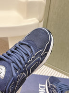 Navy Dior unisex sneaker close-up of laces and side logo with white edge trim