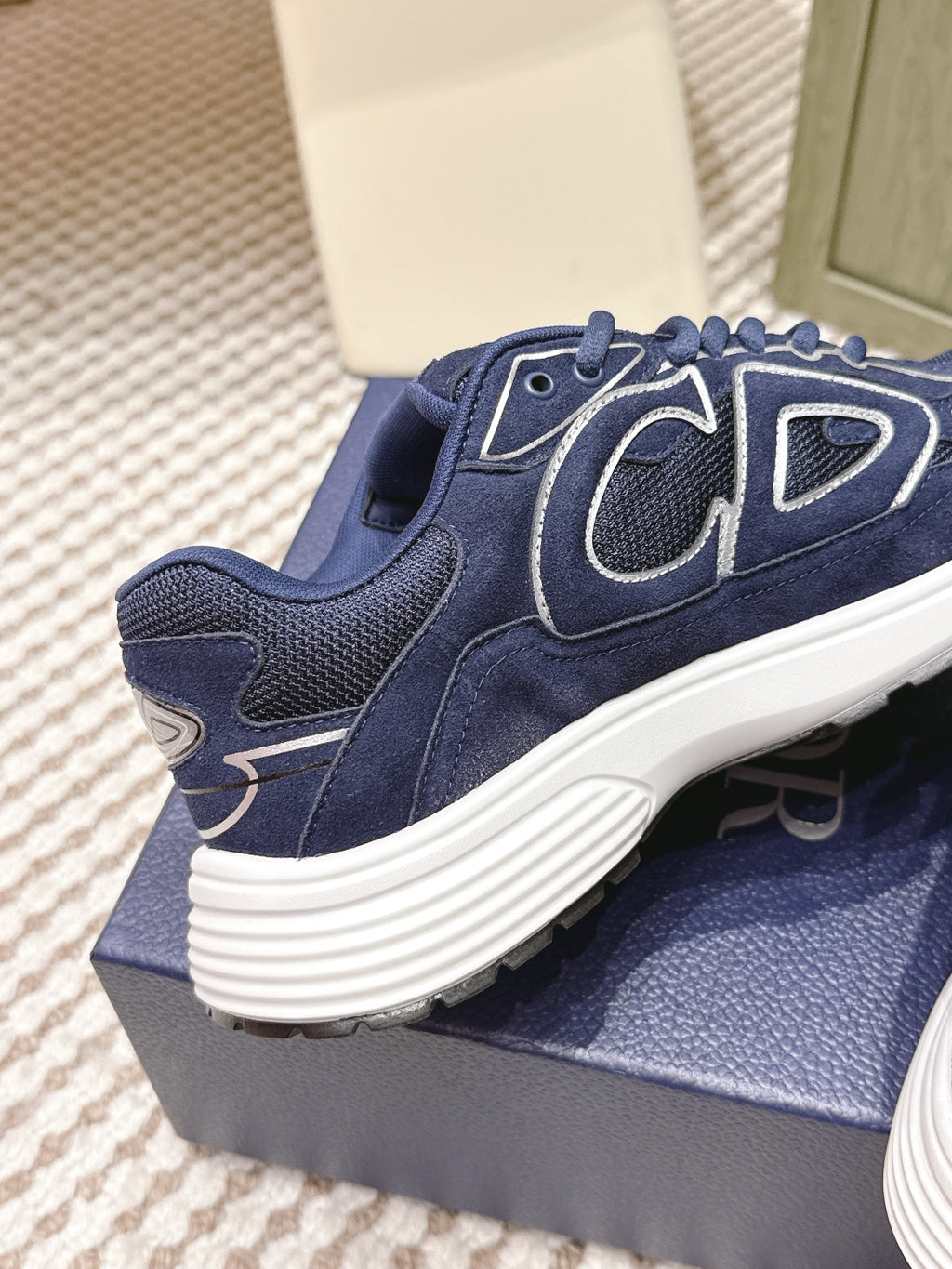 Navy Dior unisex sneaker side view with textured paneling and ribbed white sole