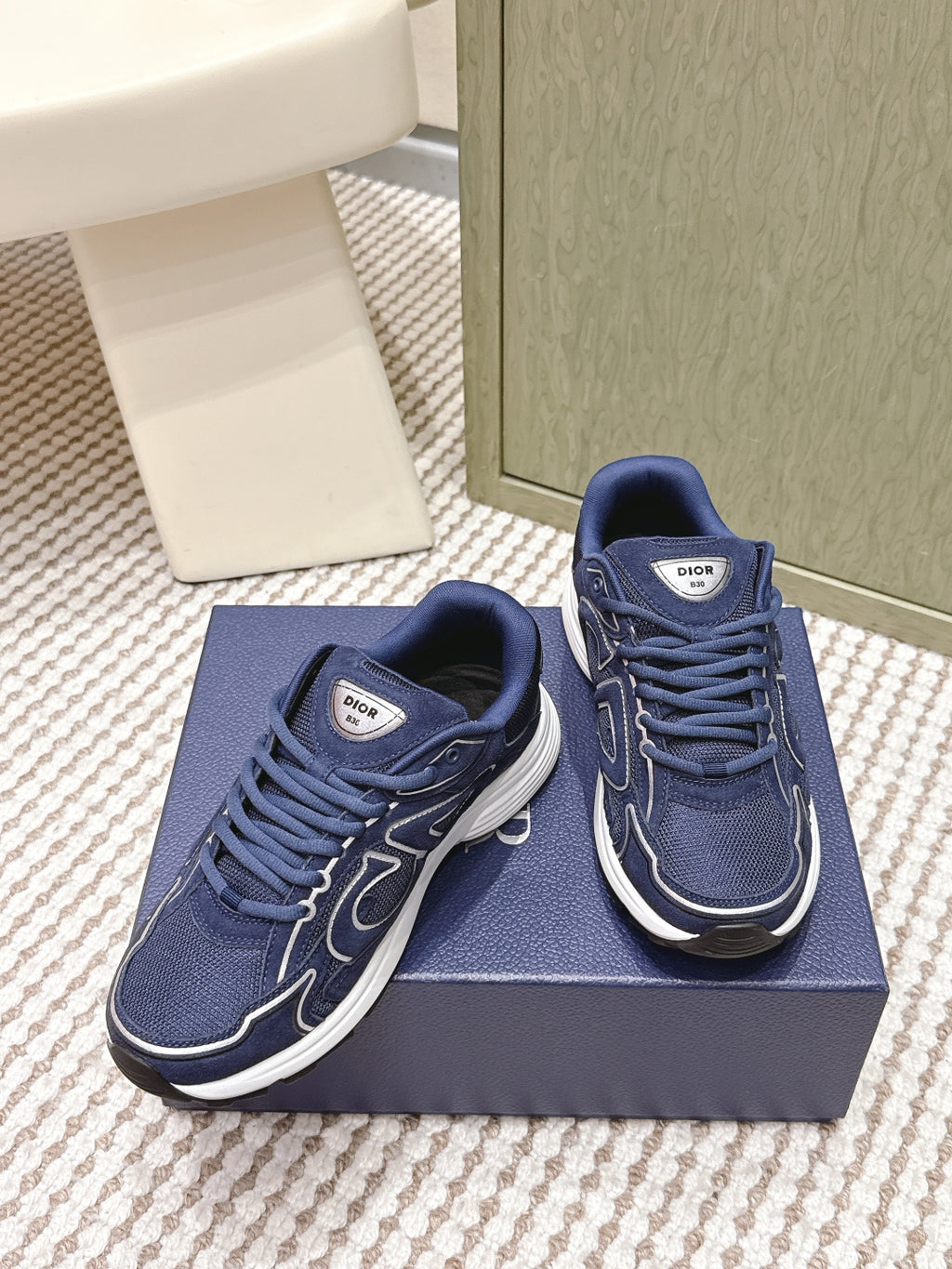 Navy Dior unisex sneakers with lace-up design and white rubber soles, side view