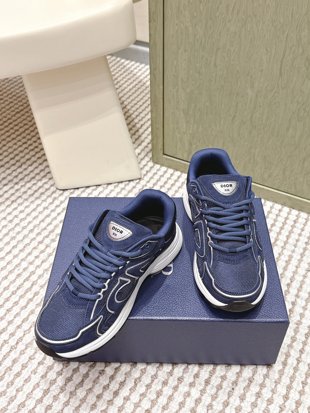 Navy Dior unisex sneakers with lace-up design and white rubber soles, side view