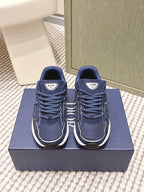 Navy Dior unisex sneakers with white midsoles and lace-up front, on blue box