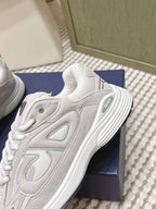 White Dior sneakers close-up of upper and side panel texture, on navy box.