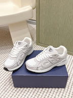 White Dior low-top sneakers, side view, with raised textured logo and laces.