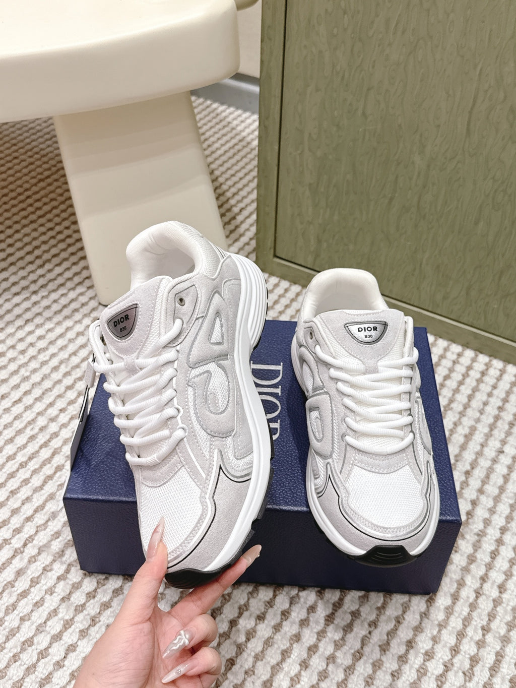 White Dior sneakers, side and heel close-up, showing laces and logo tongue label.